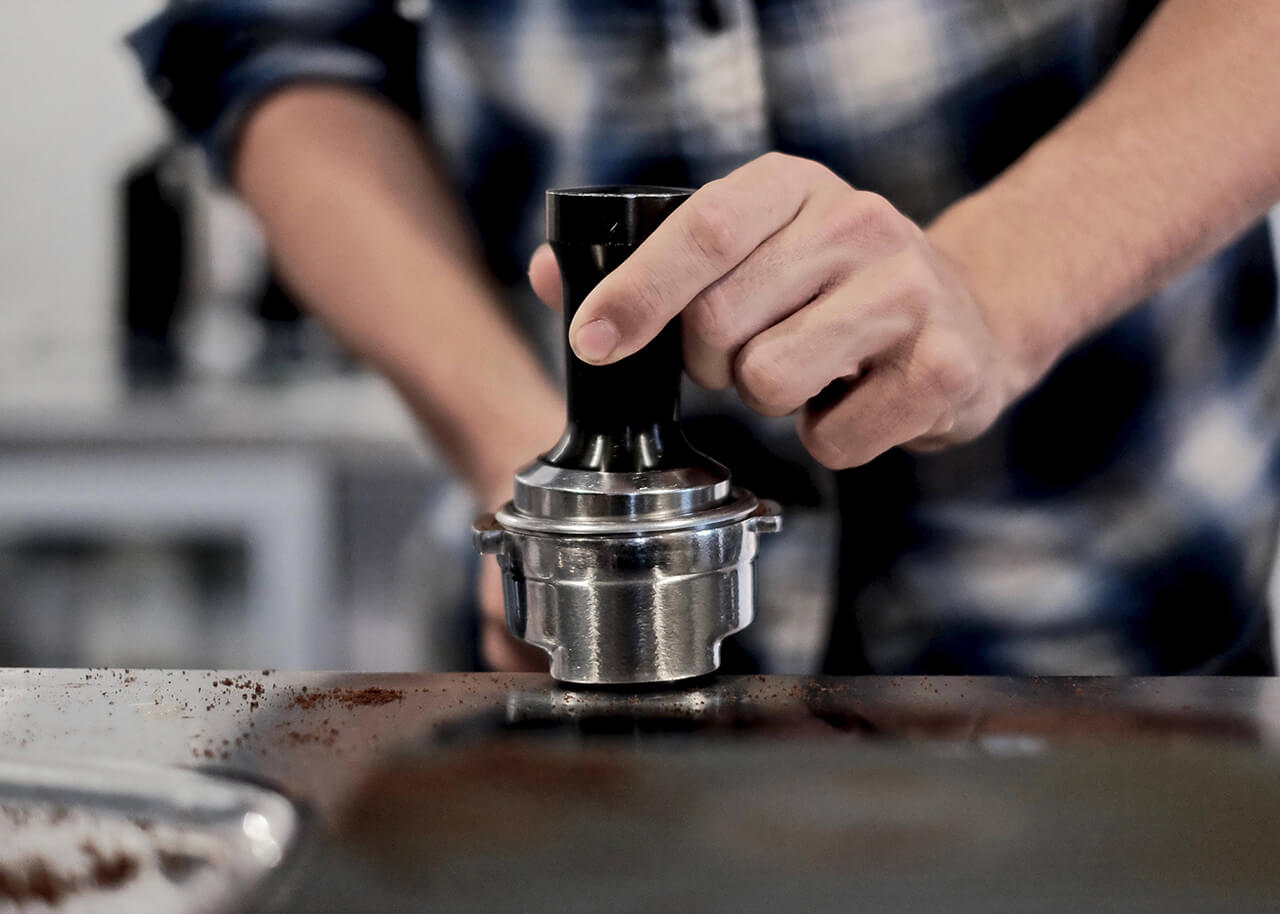 Barista Grinding Coffee At The Coffee Shop Newcastle - RV Rental Australia - Campervan Rental Shop